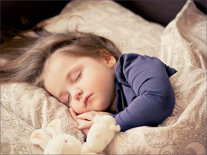 귀여운 여자 아이가 침대에서 자는 모습